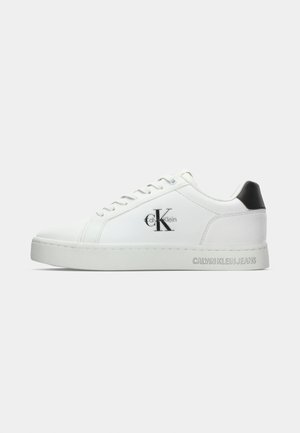 Basket en cuir blanc avec un bout rond, une semelle plate et un accent de talon noir. Présente le logo Calvin Klein en noir sur le côté et le nom de la marque embossé.