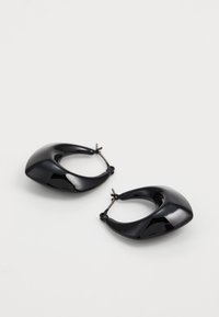 Boucles d'oreilles noires brillantes en forme de hoop avec un design abstrait courbé et un fermoir sécurisé, exhibant une texture lisse et une silhouette moderne.