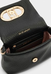 Borsa a tracolla in pelle nera con texture, presenta una chiusura ovale dorata con logo, tasca interna con zip e dettagli in oro.