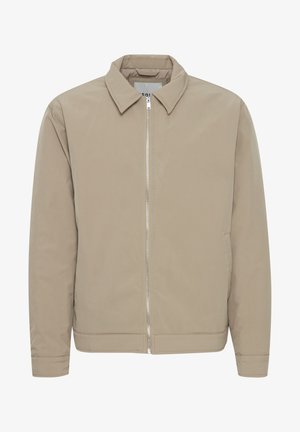 Svetlo bež jopič z zadrgo, ovratnikom, dolgimi rokavi in gladko teksturo. Ima stranske žepe in preprost dizajn.