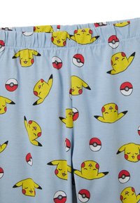 Blaue Schlafshorts mit einem umfassenden Druck von gelben Pikachu-Charakteren und Poké Bällen. Der Stoff hat eine weiche, glatte Textur.