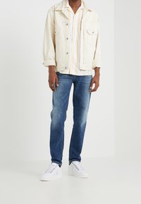 Kerman denim takki, pystysuorassa raidassa lyhythihainen paita keltaisena ja valkoisena, siniset farkut ja valkoiset tennarit. Rentoa asua kerrospinnoilla.