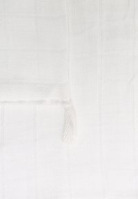 White woven textile with a grid pattern, featuring a soft texture and a small fringed edge detail.