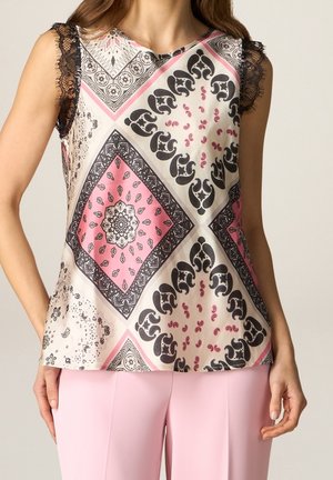 Sleeveless satin top with black lace trim, featuring pink and black intricate paisley and geometric patterns, paired with light pink pants.