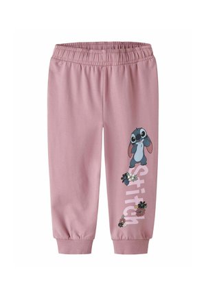 Pantalon de jogging rose pour enfants avec taille et poignets élastiques, présentant un personnage de dessin animé et des fleurs décoratives sur la jambe droite.