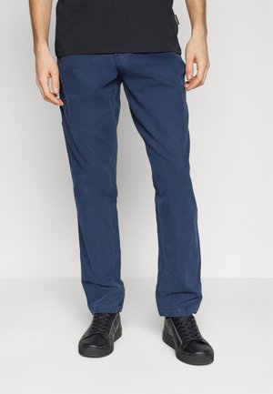 Pantaloni in cotone blu navy con una vestibilità comoda e gambe dritti; abbinati a sneakers nere con lacci e una t-shirt nera.