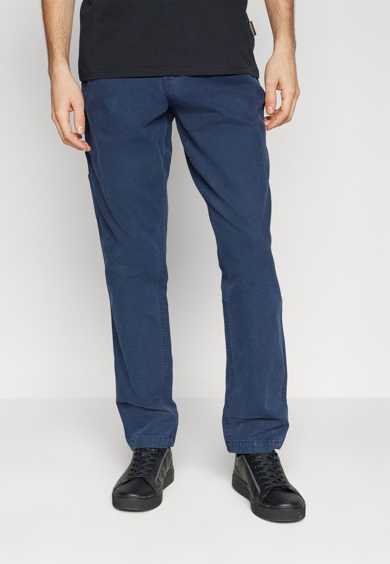 Pantaloni in cotone blu navy con una vestibilità comoda e gambe dritti; abbinati a sneakers nere con lacci e una t-shirt nera.
