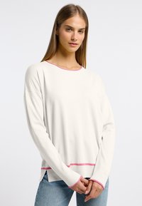 Witte lange mouwen trui met een ronde halslijn, roze details bij de kraag en onderrand, geribbelde manchetten en zijsplitten voor extra comfort.