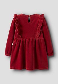 Rotes Samtkleid mit langen Ärmeln, Rüschendetails an den Schultern, einem Schlüsselrücken-Öffnung und einem gerafften Saum. Enthält ein kleines Logotag.