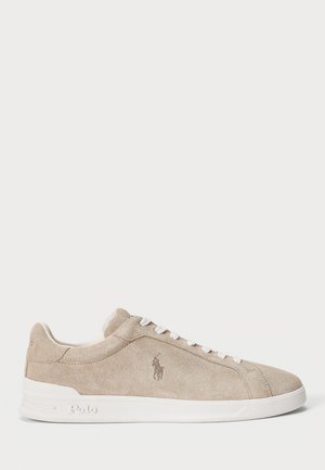 Baskets basses en daim beige avec des lacets blancs, une semelle blanche et le logo Polo embossé sur le côté et la semelle.