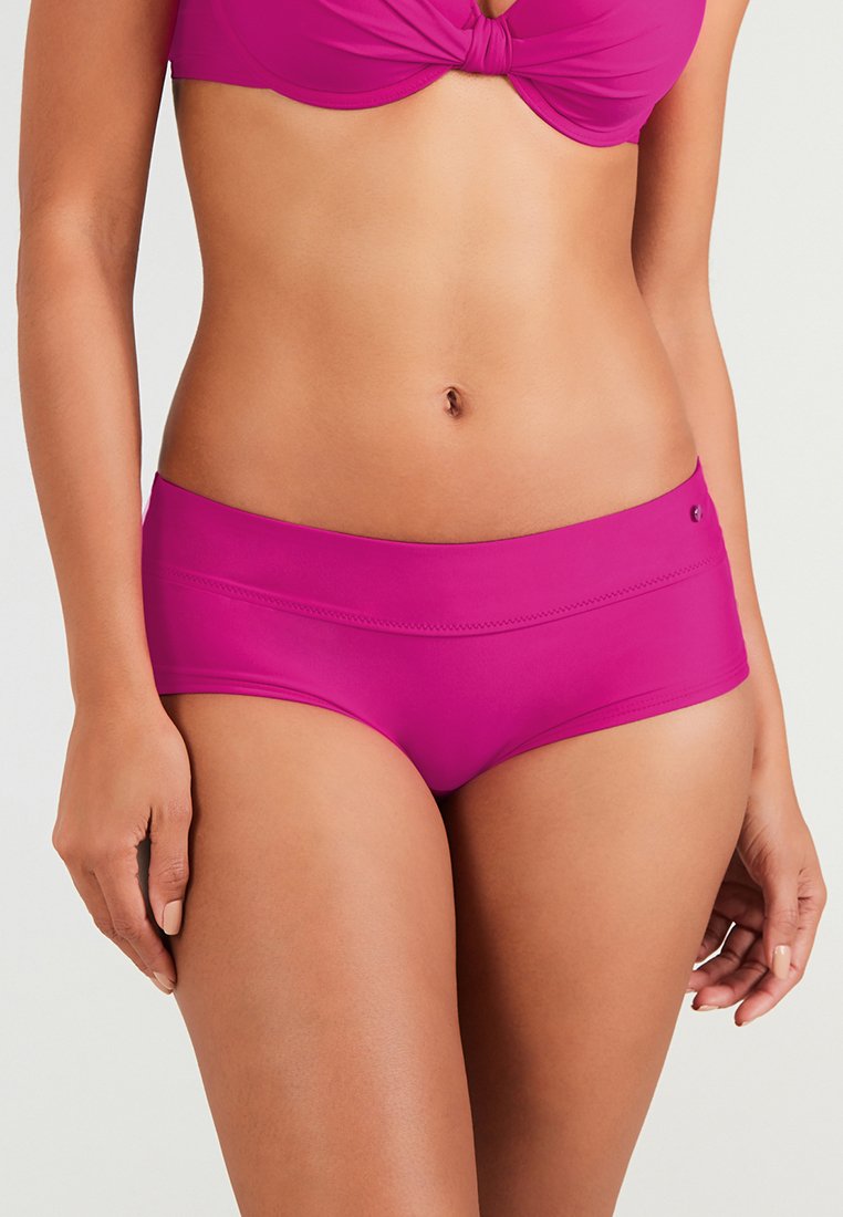 Rosa Bikini-Hosen aus glattem, dehnbarem Stoff. Sie besitzen einen breiteren Bund, dezente Nähte und ein kleines Logodesign an der Seite.