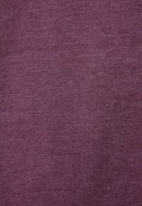 Fioletowa tkanina o gładkiej fakturze i lekkiej rozciągliwości, z równomiernym, regularnym wzorem splotu. Brak widocznych ozdób czy elementów metalowych.