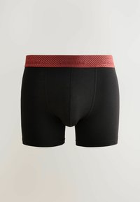 Boxeri negri cu un tiv roșu, prezentând modelul "SIGNATURE". Realizați dintr-un material moale și elastic, cu un design ajustat.