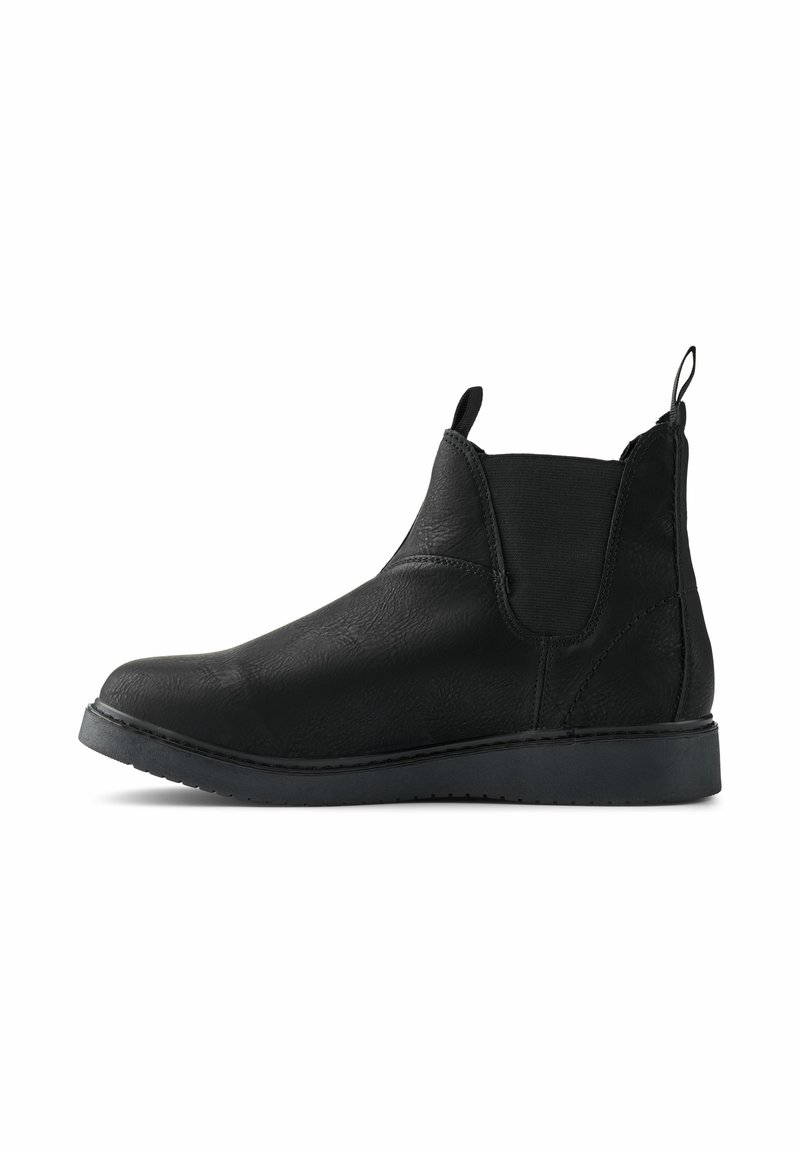 Botas de tobillo de cuero negro con un acabado suave, paneles laterales elásticos y una lengüeta en la parte posterior. Diseñadas con una suela de goma plana.