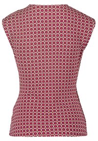 Chemise sans manches ajustée avec un col haut, présentant un motif géométrique répétitif dans des tons de rose, rouge et blanc.