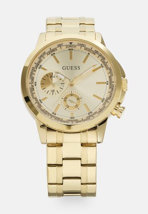 Goldfarbene Armbanduhr mit rundem Gehäuse, strukturiertem Ziffernblatt und drei Hilfszifferblättern. Verfügt über ein Gliederarmband und Stadt Namen, die auf der Lünette eingraviert sind.