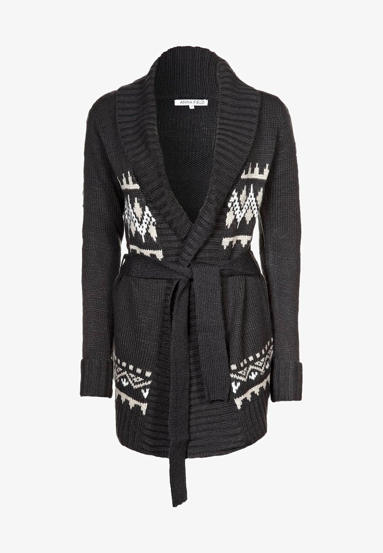 Czarny sweter na drutach z kołnierzem typu szal, ozdobiony białymi geometrycznymi wzorami, z paskiem do wiązania w talii oraz ściągaczami na rękawach dla kontrastu faktur.