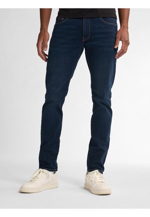Tmavě modré džíny slim fit, vyrobené z denimu, s předními kapsami a jemnými detaily prošívání. V kombinaci s bílými teniskami.
