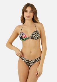 Bikini set s trojúhelníkovými košíčky; jedna strana má černou látku s květinovým vzorem, druhá strana má leopardí potisk; odpovídající spodní díl s leopardím potiskem.