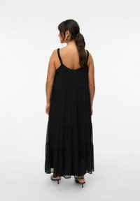 Robe maxi noire avec des bretelles fines froncées, un design à volants et un matériau transparent à l'ourlet, avec une coupe ample et un dos arrondi.