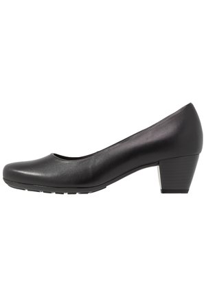 Svart läderpumps med rundad tå, låg blockklack och slät yta. Har en ren, enkel design med en liten glans.