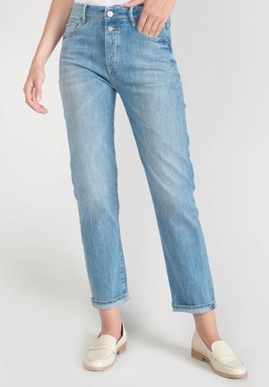 Lichtblauwe denim jeans met een rechte snit, vijf zakken en een knoopsluiting aan de voorkant. Draagt bij crème instappers en opgerolde pijpen.