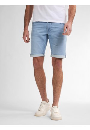 Light blue denim shorts with rolled cuffs, paired with white sneakers. The fabric has a soft texture and a relaxed fit.