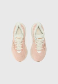 Zapatillas deportivas de color rosa claro con parte superior de malla transpirable, detalles en blanco y cordones. Cuentan con una suela acolchada y un branding sutil.