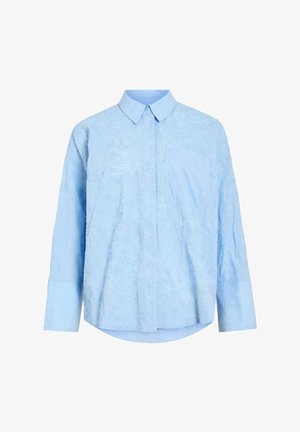 Light blue long-sleeve shirt with subtle embossed floral pattern, pointed collar, front pocket, and buttoned cuffs.