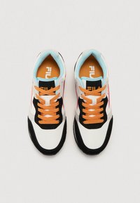 White and black sneakers feature orange laces, light blue accents, and a cushioned sole. Fila logo on tongue and side. Textile and synthetic materials.