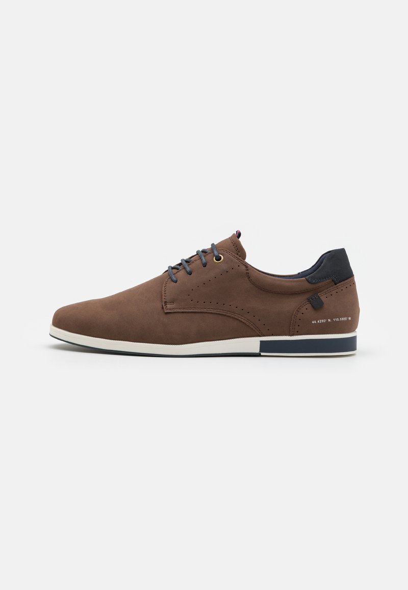 Zapatos de cuero marrón con una textura suave, que cuentan con acentos en azul marino, cordones redondos, detalles perforados y una suela de goma blanca.