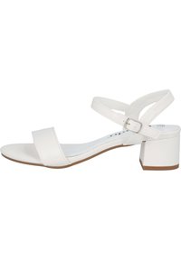 Weiße Absatzsandale mit einem glatten, kunstledernen Obermaterial, zwei breiten Riemen, einem Knöchelverschluss und einem Blockabsatz. Flache Sohle mit einem hellbraunen Akzent.