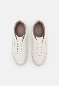 Hvide lædersneakers med subtile grå detaljer, snørebåndsdesign og beige strukturerede indersåler. Har branding på siden og tungen.
