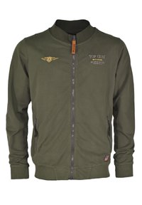 Oliwkowa kurtka bombowca z zamkiem błyskawicznym, prążkowanymi mankietami i dołem. Posiada wyszywane logo "Top Gun" oraz skrzydlatą naszywkę na piersi.