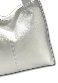 White leather handbag with a textured surface, curved silhouette, and reinforced stitching along the seams. Single strap for carrying.