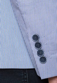 Pasiasty rękaw marynarki w jasnoniebieskim i białym kolorze, z czterema ciemnoniebieskimi guzikami z detalami szycia. Gładka tekstura materiału i dopasowany fason.