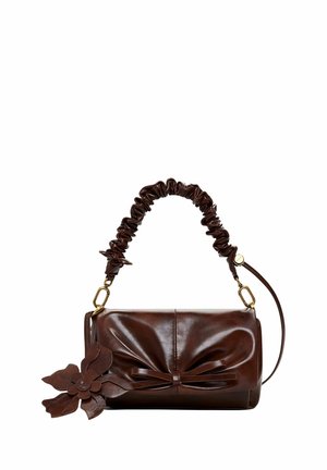 Donkerbruine leren handtas met geplooide handgreep, decoratieve strik aan de voorkant en een grote bloemvormige leren hanger aan de zijkant.
