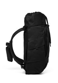 Sac à dos noir avec bretelles rembourrées, plusieurs compartiments zippés et une poche latérale à rabat, vu de côté sur un fond blanc.