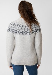 Knit sweater in light gray with a contrasting darker geometric pattern on the yoke. Made of soft material, featuring a relaxed fit.