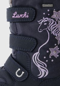Mørkeblå barneboots med lilla enhjørningdesign, glitrende detaljer og to borrelåsremmer. Har en hestesko og SympaTex-merke.