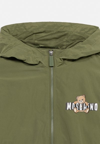 Olive green jacket with hood, front zipper, and a teddy bear logo holding "Moschino" text on the chest.