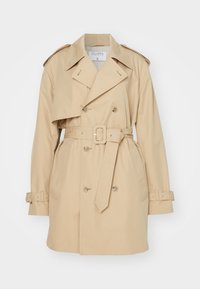 Trench-coat beige à double boutonnage avec un col large, une ceinture, des épaulettes et des brides de manches boutonnées.
