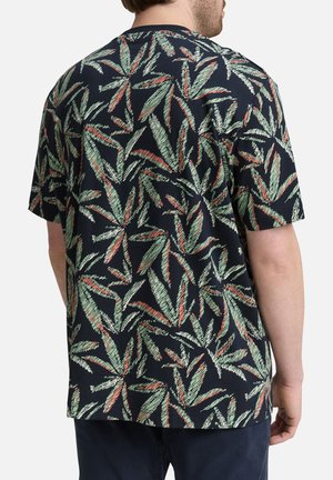 Chemise en coton à manches courtes avec un fond sombre et un motif de feuilles répétitif en vert et rouge. Coupe décontractée avec un col rond.