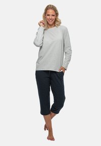 Lichtgrijs langemouwen top gecombineerd met marineblauwe korte broek met stippen. Zachte stof, relaxed fit, met een trekkoord in de taille.