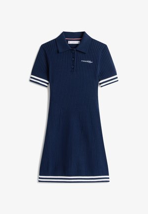 Abito polo blu navy a coste con colletto, tre bottoni e accenti bianchi sulle maniche corte. Vestibilità sagomata con gonna svasata.