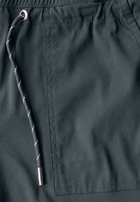 Mörkgrått tyg med en slät textur, med en elastisk midja och ett svart snöre med silverdetaljer och sömnadsdetaljer.