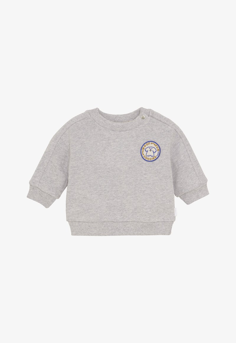 Sweat-shirt bébé gris clair à manches longues et col rond, avec un petit patch rond représentant un chien et du texte sur la poitrine.