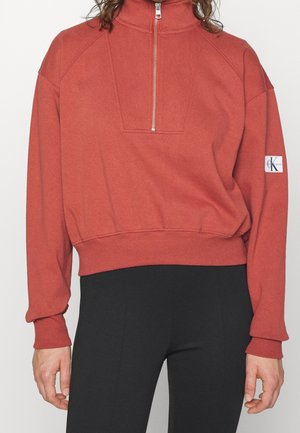 Rode zip-up sweatshirt met een hoge kraag, verlaagde schouders, ribbed manchetten en zoom. Heeft een logo patch op de linkersleeve.