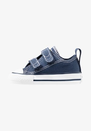 Marineblauwe canvas sneakers met twee klittenbandsluitingen, witte rubberen teencap, gestructureerde zool en contrasterend witte stiksels en accenten.
