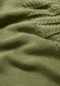 Tissu tricoté vert avec une texture lisse et un motif en relief de tricot en câble le long d'un bord. La couleur est un vert olive doux et atténué.